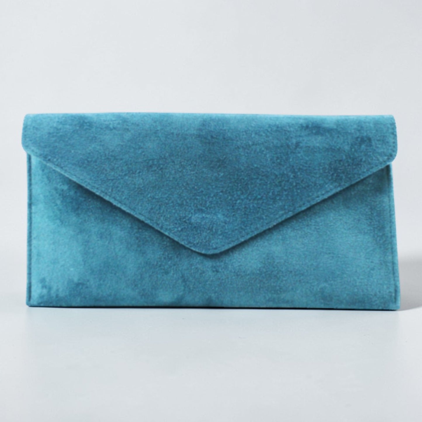 Blue suede clutch bag on a light gray background