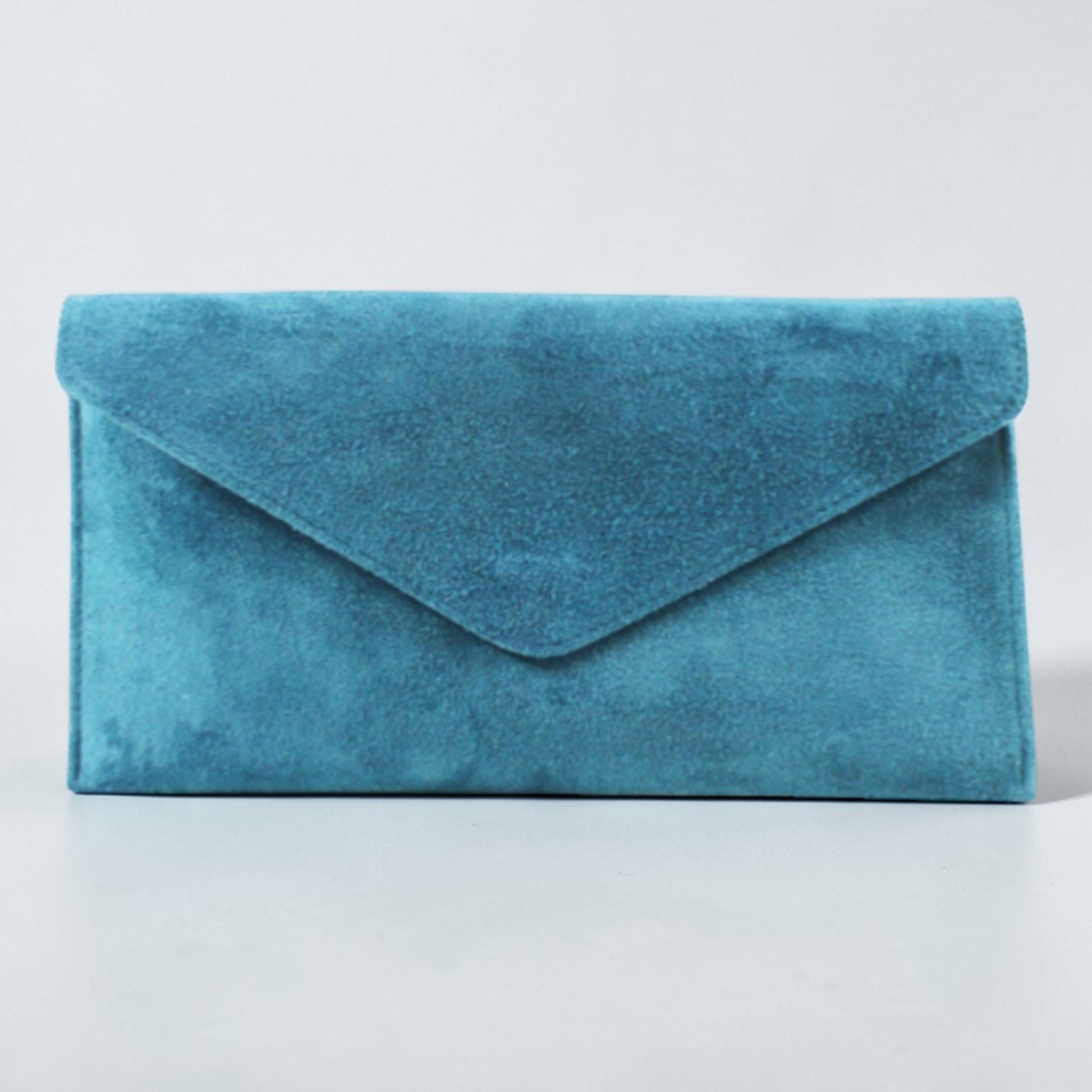 Blue suede clutch bag on a light gray background